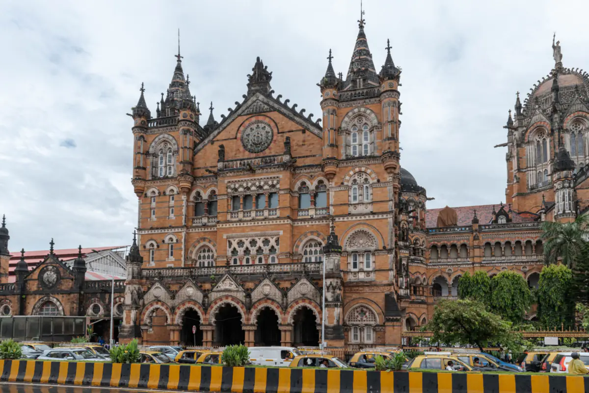 The Gothic facade of Chhatrapati Shivaji Maharaj Terminus in Mumbai, with spires and arches above a row of taxis